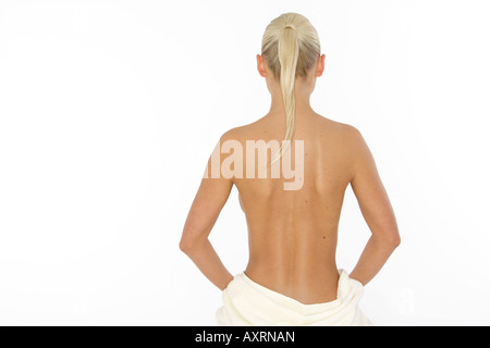 Blonde junge Frau eingewickelt in ein Handtuch, Rückansicht Stockfoto