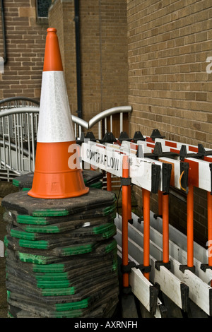 Nahaufnahme von PVC fluoreszierende Contra Fluss Straße Zapfen und Barrieren gestapelt gegen eine Gebäudewand in UK Stockfoto