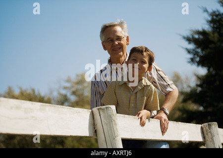 Opa und Enkel außerhalb stützte sich auf Zaun Stockfoto