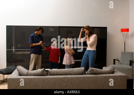 Porträt von zwei Kindern stört ihre Eltern, die beschäftigt sind. Stockfoto