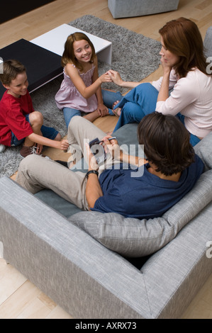 Porträt von zwei Kindern stört ihre Eltern, die beschäftigt sind. Stockfoto