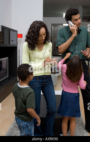 Porträt von zwei Kindern stört ihre Eltern, die beschäftigt sind. Stockfoto