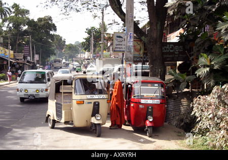 Sri Lanka tuk tuk: ein buddhistischer Priester warten auf Ein tuk tuk Taxi, street scene, Kandy, Sri Lanka, Asien Stockfoto