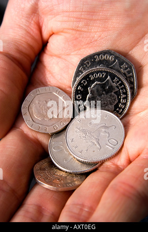 Britische Münzen in der Handfläche der Hand eines Mannes Stockfoto