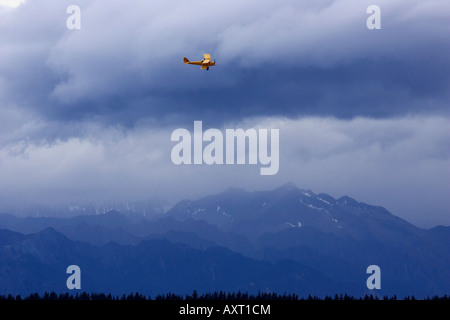 Tiger Moth Doppeldecker Gewitterwolken und Berge in der Nähe von Wanaka Neuseeland Südinsel Stockfoto