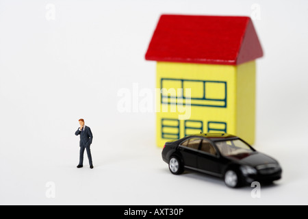 Geschäftsmann Figur vor einem Haus und ein Auto Stockfoto