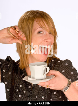 Eine glückliche junge Frau mit Zuckerzangen und Zuckerwürfel. Stockfoto