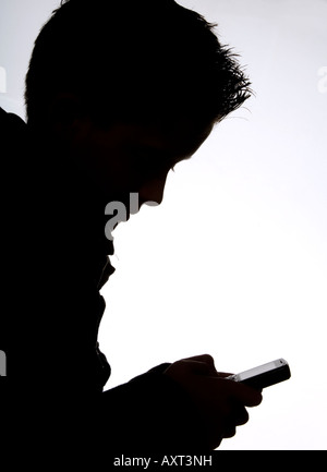 Eine Silhouette von Teenager mit dem Handy telefonieren. Bild von Jim Holden Stockfoto