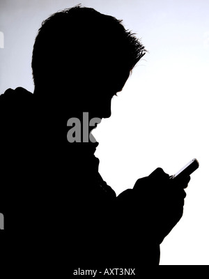 Eine Silhouette der Teenager SMS mit Handy. Bild von Jim Holden. Stockfoto