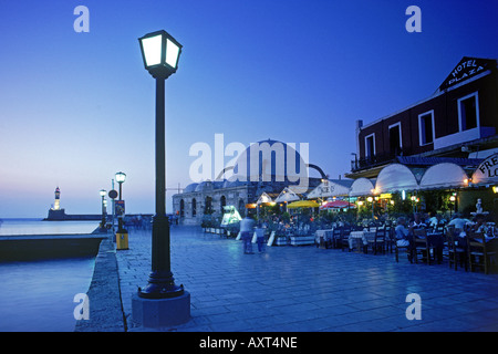 Lampenlicht und Outdoor-Restaurants entlang der Uferpromenade im Hafen von Chania auf Kreta Stockfoto