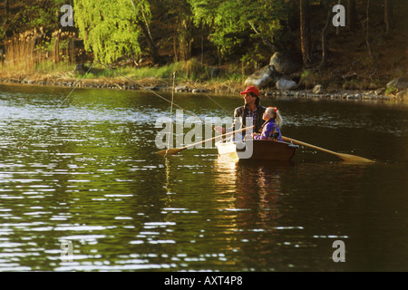 Vater und Tochter Angeln im See von kleines Ruderboot im Abendlicht Stockfoto