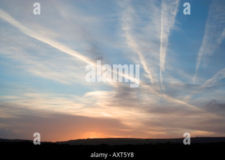 Flugzeug-Kondensstreifen über den Himmel. Transatlantische Flüge nach die Baken über britischen Küste. Sonnenuntergang. Stockfoto