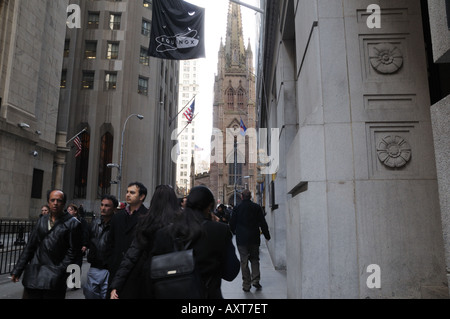 Im Schatten der historischen Dreifaltigkeitskirche drängen sich Touristen und Büroangestellte Wall Street in Manhattan. Stockfoto