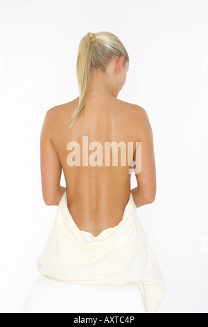 Blonde junge Frau eingewickelt in ein Handtuch, Rückansicht Stockfoto