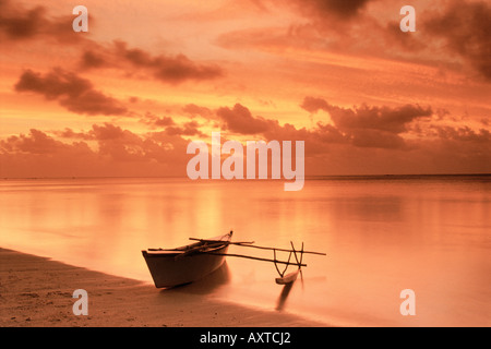 Ausleger-Kanu am Ufer in Aitutaki Lagune bei Sonnenuntergang in der Cook Inseln South Pacific Stockfoto