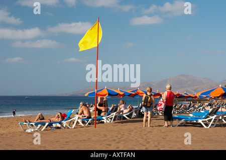 Gelbe Flagge am Strand von Puerto del Carmen auf Lanzarote auf den Kanarischen Inseln. Stockfoto