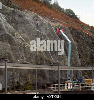 Rock Verschraubung der Felswand zu einer Wasseraufbereitungsanlage unter Schutz vor Steinschlag in Nord-Wales Stockfoto