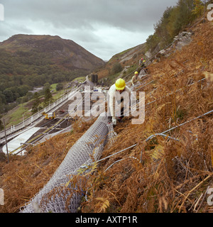 Rock Verschraubung der Felswand zu einer Wasseraufbereitungsanlage unter Schutz vor Steinschlag in Nord-Wales Stockfoto