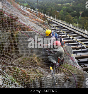 Rock Verschraubung der Felswand zu einer Wasseraufbereitungsanlage unter Schutz vor Steinschlag in Nord-Wales Stockfoto