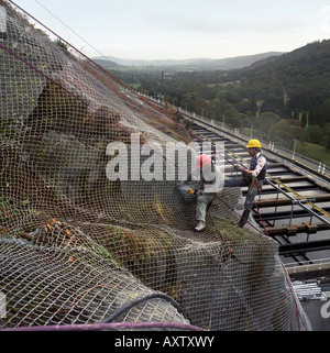 Rock Verschraubung der Felswand zu einer Wasseraufbereitungsanlage unter Schutz vor Steinschlag in Nord-Wales Stockfoto