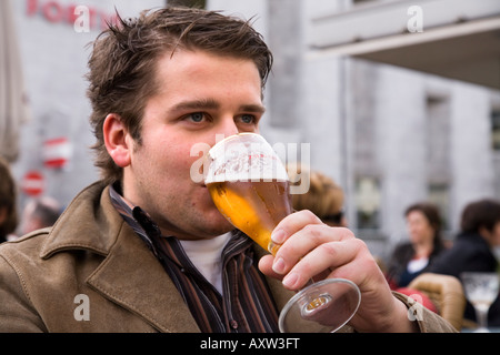 männliche Touristen nippt an ein belgisches Bier im Open-Air-Bereich von Antwerpen Bar. Belgien Stockfoto