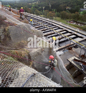 Rock Verschraubung der Felswand zu einer Wasseraufbereitungsanlage unter Schutz vor Steinschlag in Nord-Wales Stockfoto