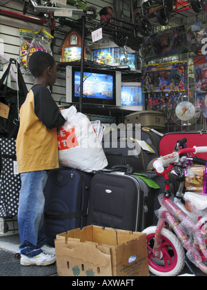 kleiner schwarzer Junge vor dem Fernseher in einem Shop, USA, New York Queens Stockfoto