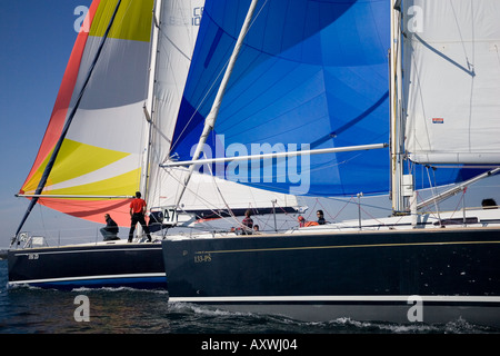 Legen Sie zwei Kreuzer Segelboote racing einander Windrichtung, mit wichtigsten Segel und Spinnaker voll Stockfoto