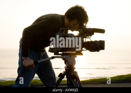 Mann-Student an der Aberystwyth University TV und Film Medienwissenschaft mit Sony-Video-Kamera und Stativ vor Ort, UK Stockfoto