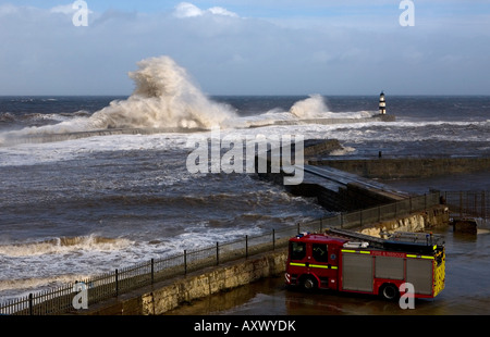 Feuerwehrleute in Ihre Fire Engine Watch riesige Meere die Pier und Leuchtturm in Seaham in der Grafschaft Durham, England hit Stockfoto