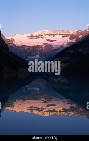 Blick zum Mount Victoria über die stillen Wasser des Lake Louise, bei Sonnenaufgang im Sommer, Banff Nationalpark, Alberta, Kanada Stockfoto