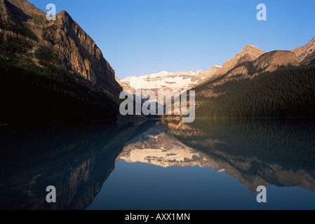 Blick zum Mount Victoria über die stillen Wasser des Lake Louise, bei Sonnenaufgang im Sommer, Banff Nationalpark, Alberta, Kanada Stockfoto