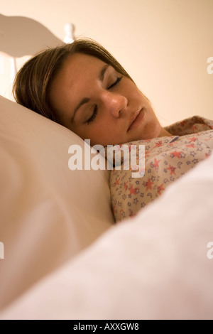Junge Frau schläft im Bett allein. Stockfoto