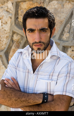 Junge arabische Mann Arme verschränkt in die Kamera schaut Stockfoto
