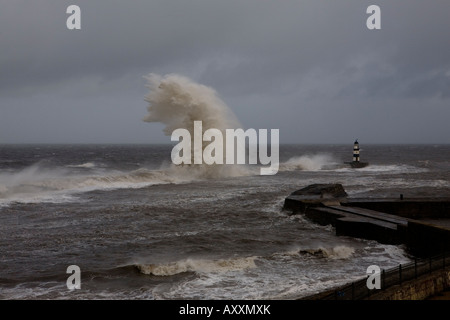 Sturmwellen brechen über die Ufermauer & Leuchtturm am Seaham Pier im Vereinigten Königreich Stockfoto