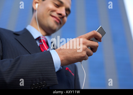 Geschäftsmann mit Kopfhörer mit einem MP3-player Stockfoto