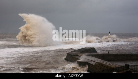 Sturmwellen brechen über die Ufermauer & Leuchtturm am Seaham Pier im Vereinigten Königreich Stockfoto