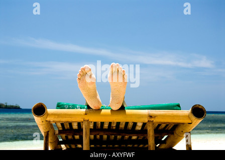 Zwei Füße auf Bambus liege tropischen Strand Urlaub Füße stellen Sie Ihre Füße oben Ruhe Entspannung Stockfoto