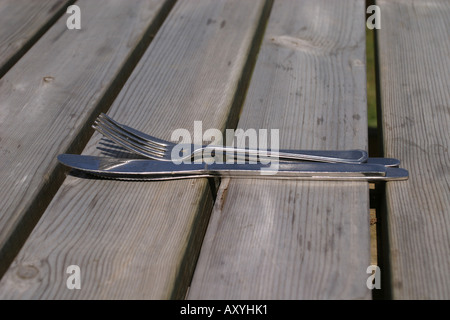 Messer und Gabel links auf Holztisch Stockfoto