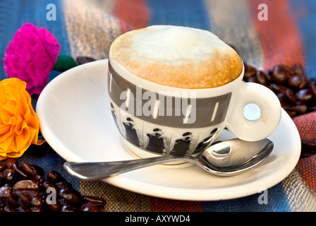 Espresso in schwarzen und weißen Tasse mit Löffel auf farbigen Hintergrund mit Haufen von Kaffeebohnen Stockfoto