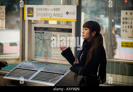 Japanische Frau raucht eine Zigarette in einem Tierheim Tokyo bus Stockfoto