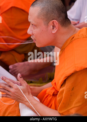 Mönch halten Faden als Teil eines religiösen Rituals beim Tattoo Festival in Thailand Stockfoto