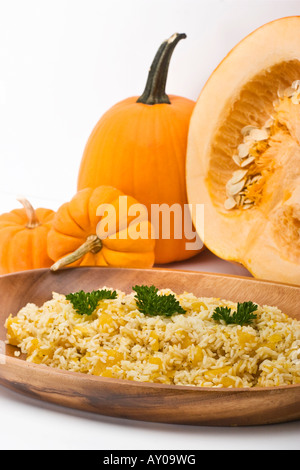 Ein Risotto, zubereitet mit geröstetem essbarem Kürbis, mit Verzierung ganzer orangener Kürbisse, niemand über der vertikalen Ebene in den USA Hi-res Stockfoto