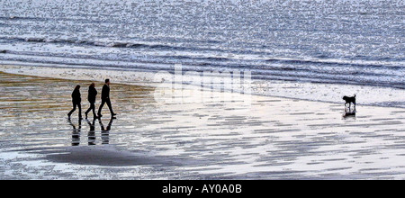 Künstlerische Darstellung von Menschen, die Hunden spazieren, am Strand von Scarborough England UK Stockfoto