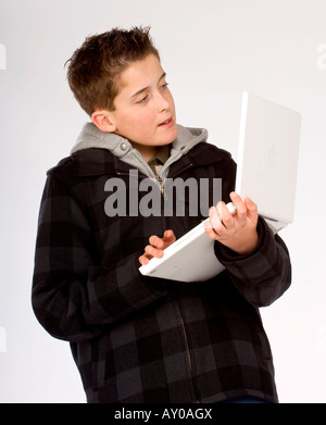 Ein Teenager mit einer Apple MacBook Laptop-Computer in seine Arme. Bild von Jim Holden Stockfoto