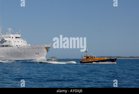 Eine große weiße Kreuzfahrtschiff ist durch die engen Fahrrinnen der Isles of Scilly geweidet. Stockfoto