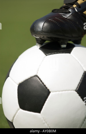 Fußballschuh auf einem Vintage schwarz-weiß Fußball Stockfoto