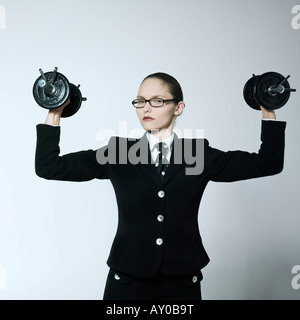Fehlschüsse Studioportrait von einer schönen jungen Frau in einem Kostüm Anzug tragen Gewichte Stockfoto