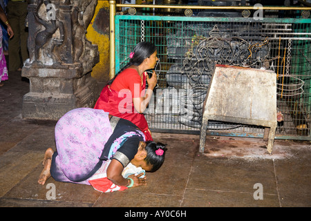 Weibliche Gläubige beten vor einem Schrein, Meenakshi Tempel, Madurai, Tamil Nadu, Indien Stockfoto