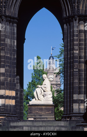 Das Scott Monument in Edinburgh, Schottland, Großbritannien. Der Uhrturm von Balmoral Hotel ist sichtbar durch den Torbogen. Stockfoto